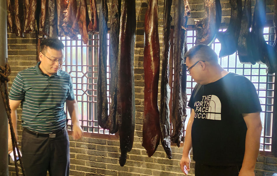 專家(jiā)們在觀摩湖(hú)湘肴“臘肉王”